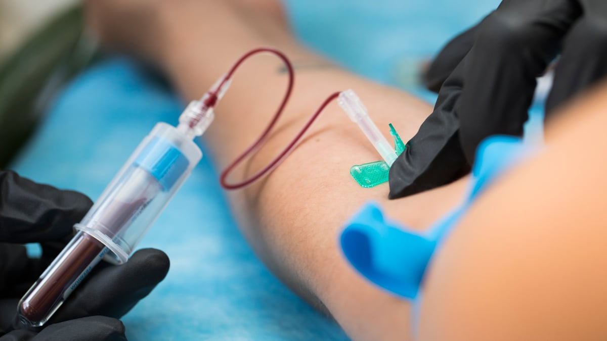 Nurse taking a blood sample from a patient in a hospital